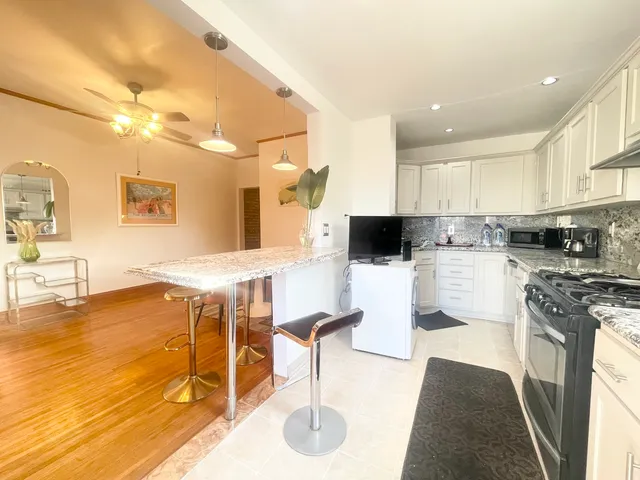 a kitchen with stainless steel appliances a refrigerator a sink a stove a microwave and cabinets