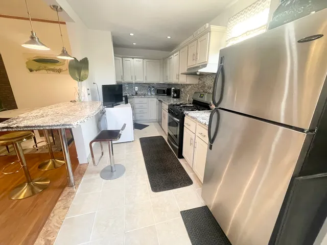a kitchen with stainless steel appliances granite countertop a refrigerator and a stove top oven