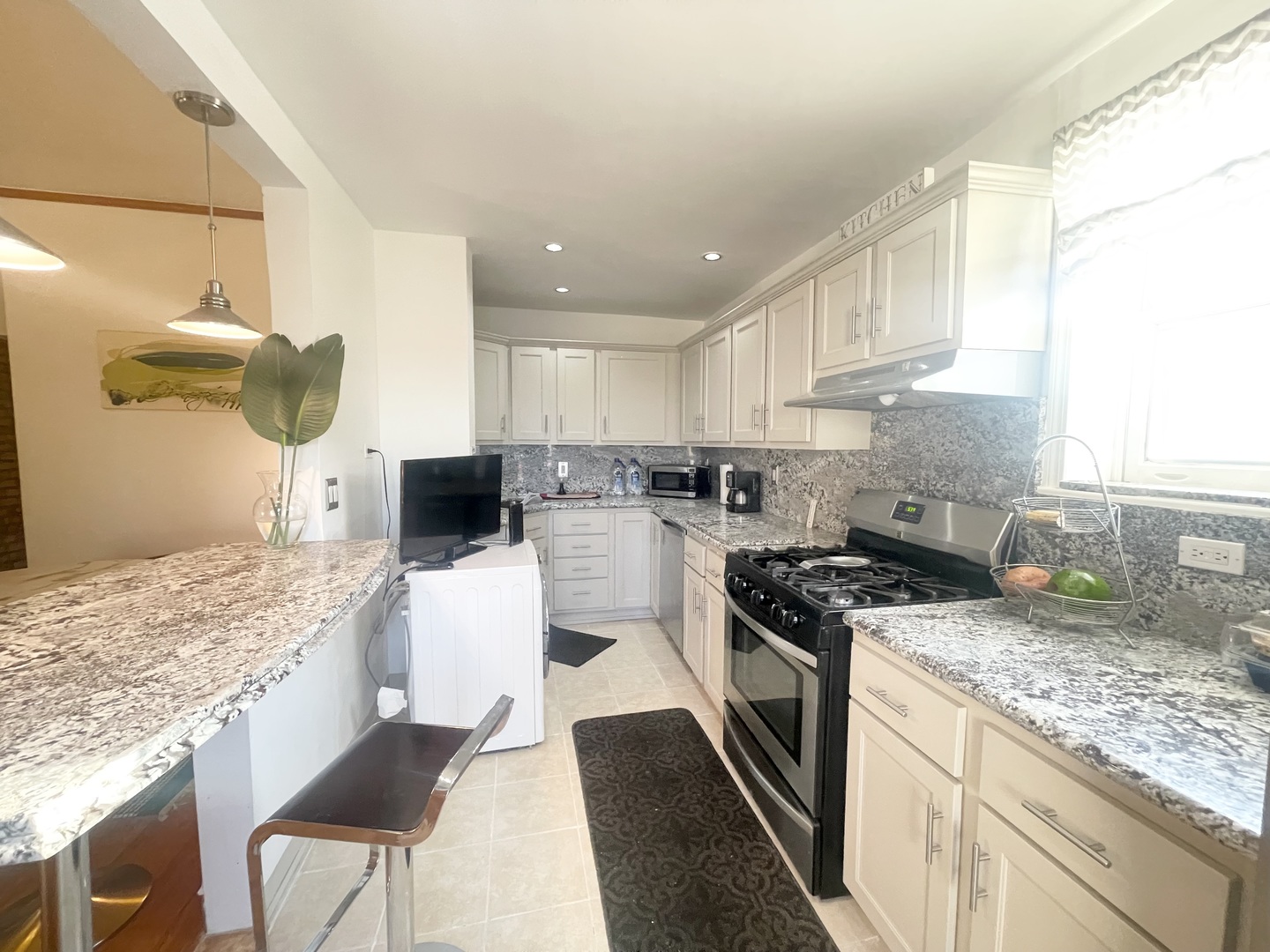 2810 West Logan Boulevard, Unit 3W Chicago, IL 60647 - Photo 27 of 34 a kitchen with a stove a sink a refrigerator and chairs