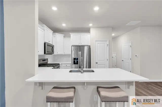 a kitchen with kitchen island a appliances a sink and a refrigerator