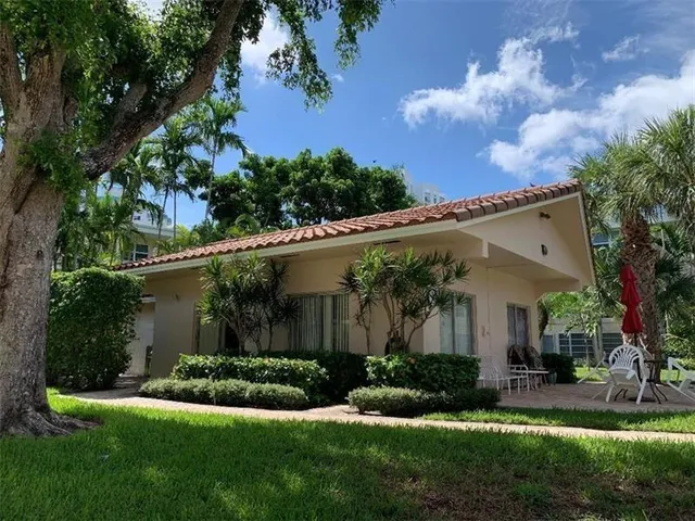 front view of house with a yard and potted plants