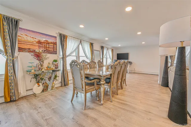 a kitchen with stainless steel appliances kitchen island granite countertop a stove a sink a refrigerator and white cabinets with wooden floor