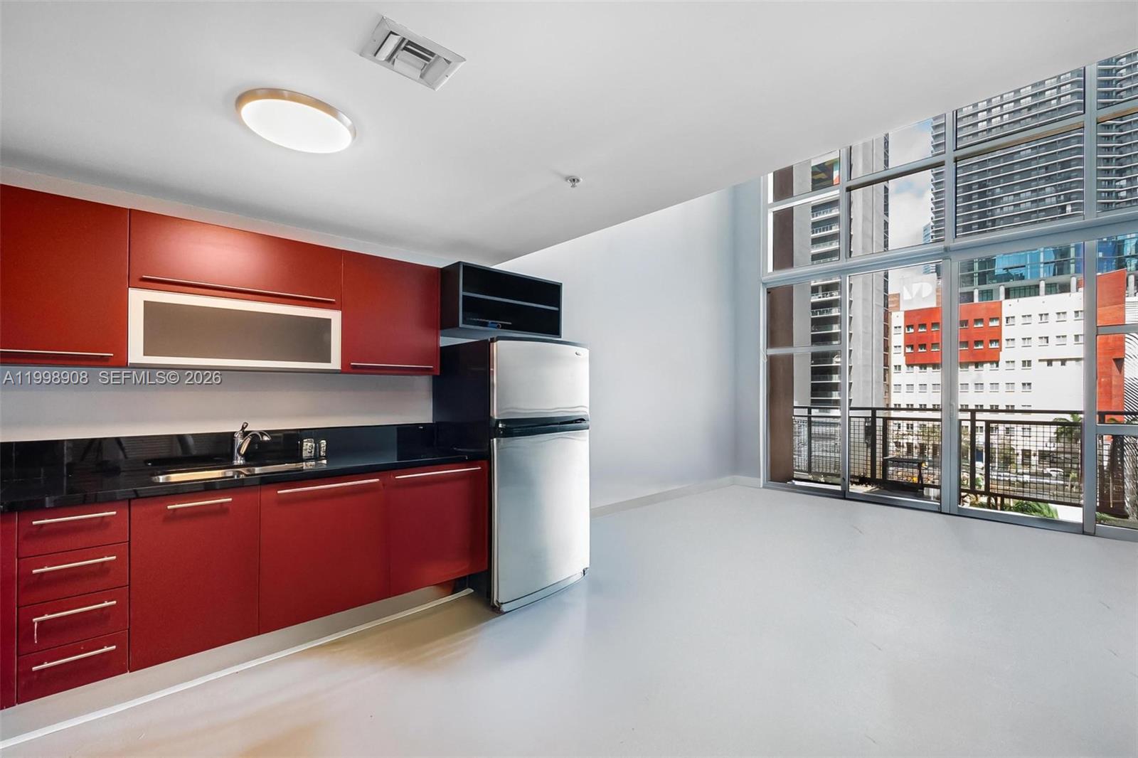 244 Biscayne Boulevard, Unit 445 Miami, FL 33132 - Photo 11 of 35 a kitchen with stainless steel appliances granite countertop a refrigerator and a sink