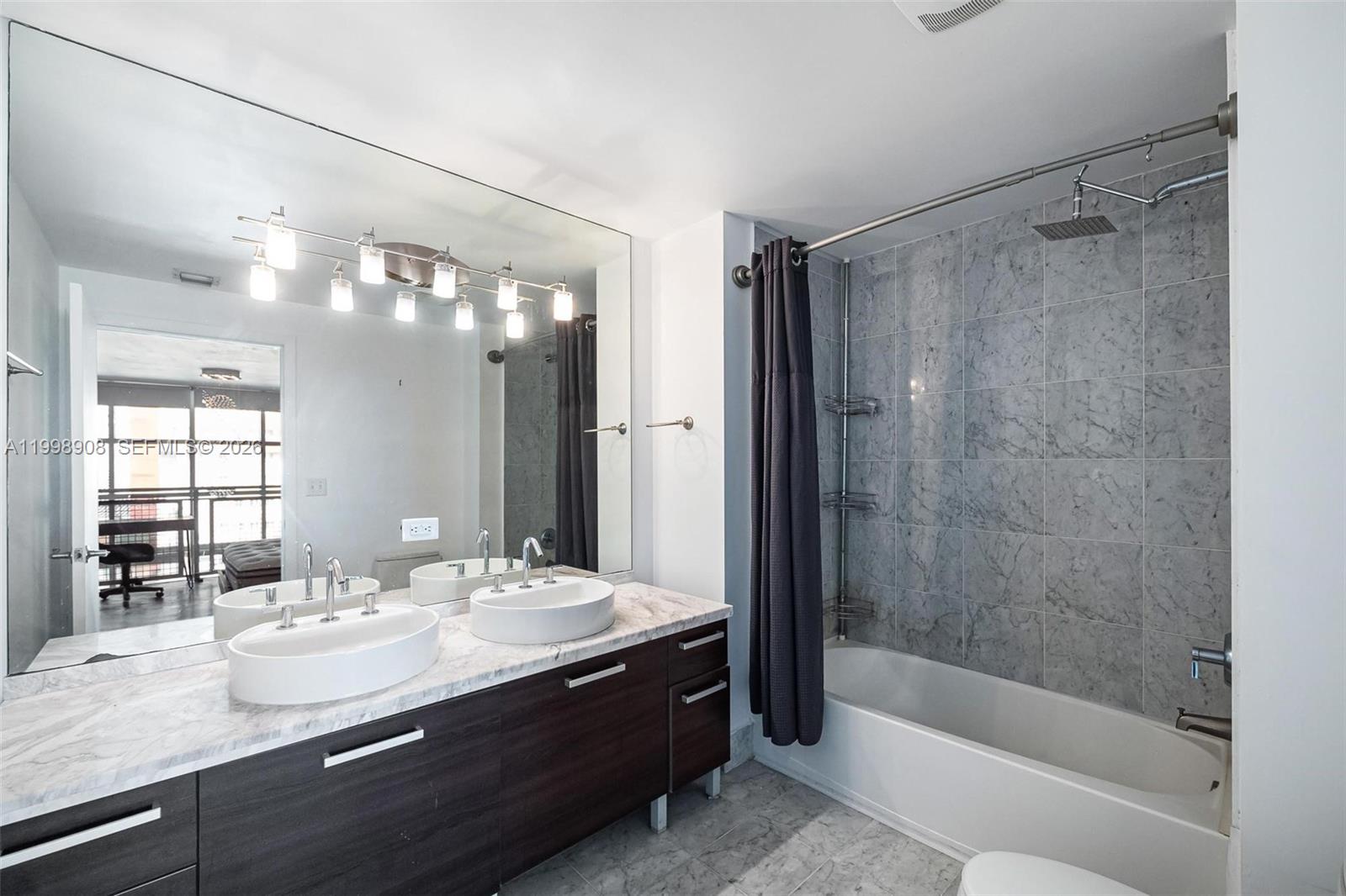 244 Biscayne Boulevard, Unit 445 Miami, FL 33132 - Photo 20 of 35 a bathroom with a bath tub sink mirror and
