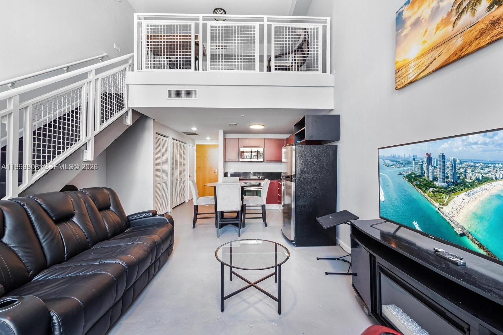 244 Biscayne Boulevard, Unit 445 Miami, FL 33132 - Photo 5 of 35 a living room with furniture ceiling fan and a window
