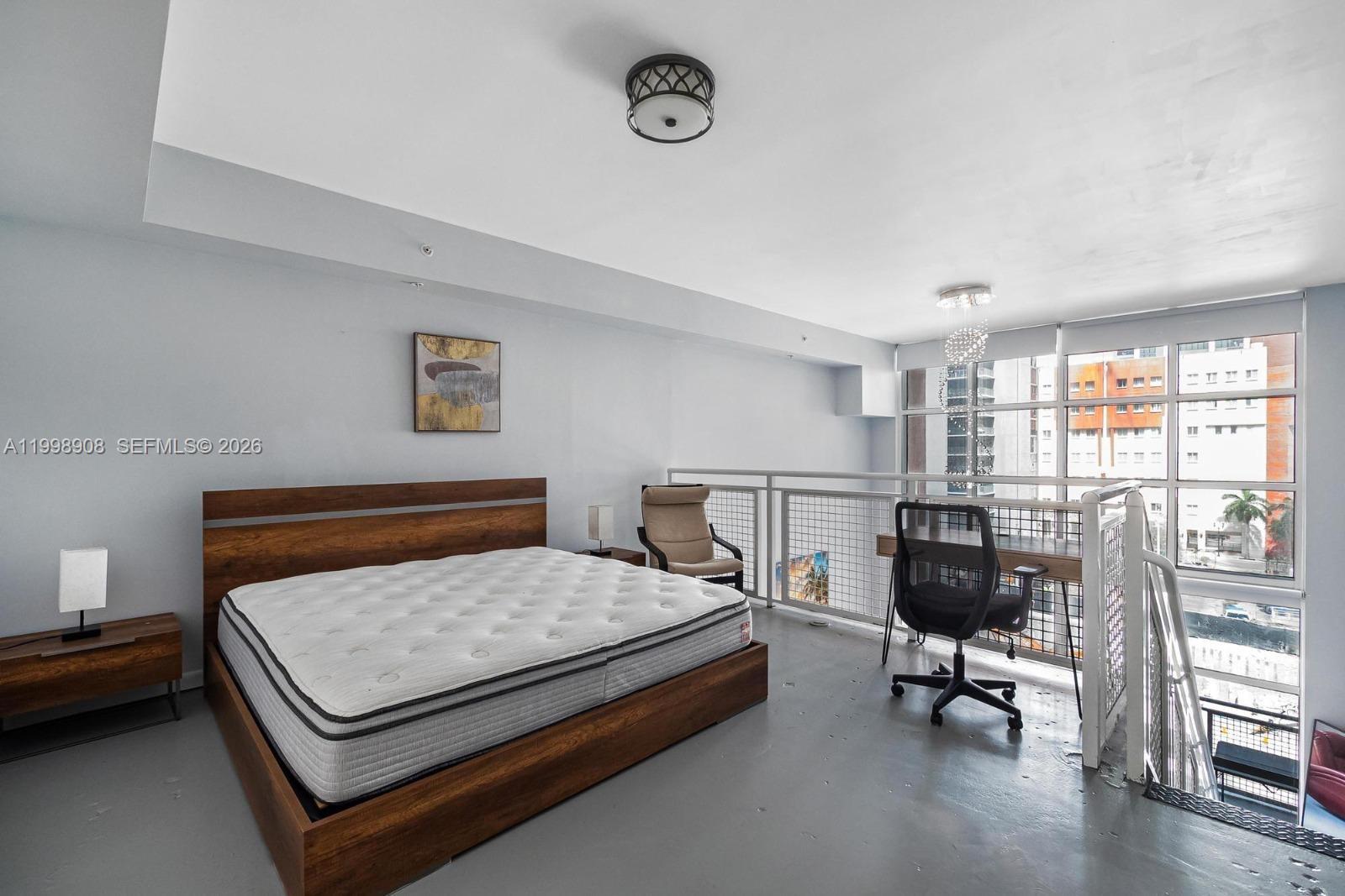 244 Biscayne Boulevard, Unit 445 Miami, FL 33132 - Photo 6 of 35 a bedroom with a bed a table and chair