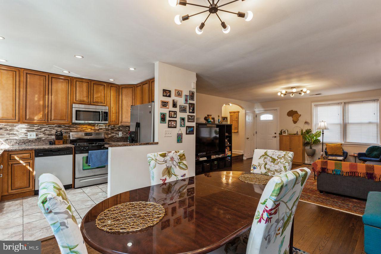 3920 Rexmere Road Baltimore, MD 21218 - Photo 14 of 35 a kitchen with stainless steel appliances granite countertop a stove a refrigerator a kitchen island a table and chairs