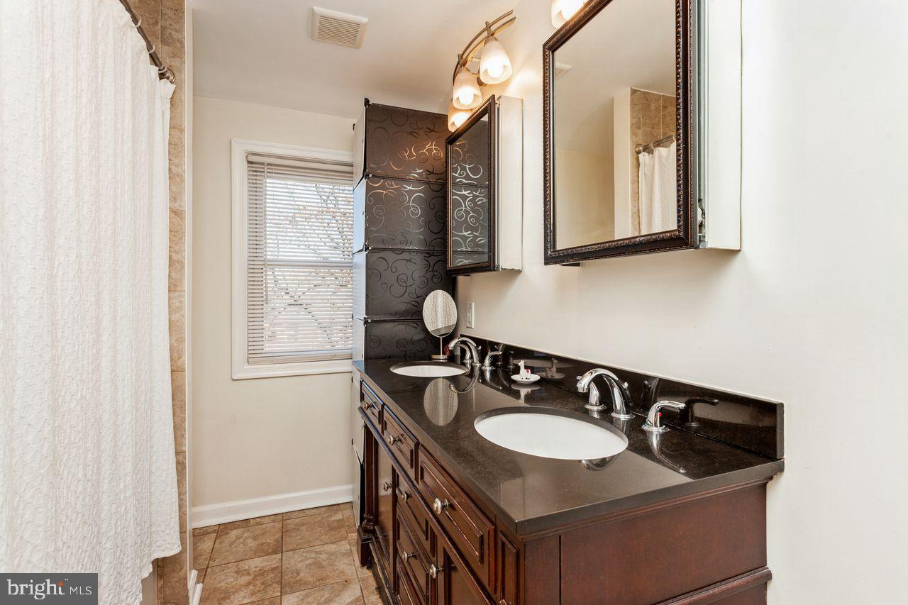 3920 Rexmere Road Baltimore, MD 21218 - Photo 24 of 35 a bathroom with a granite countertop sink and a mirror