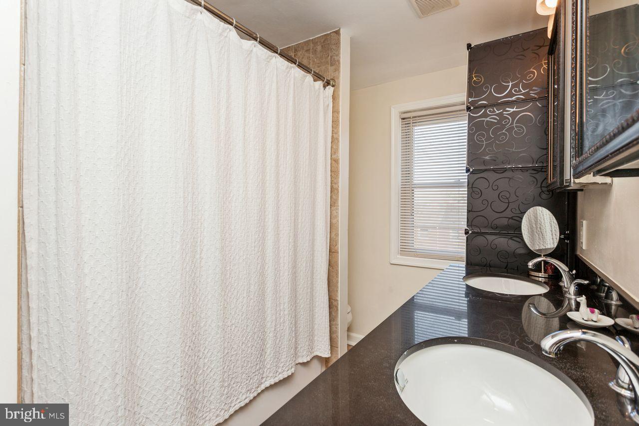 3920 Rexmere Road Baltimore, MD 21218 - Photo 26 of 35 a bathroom with a sink vanity mirror and a toilet