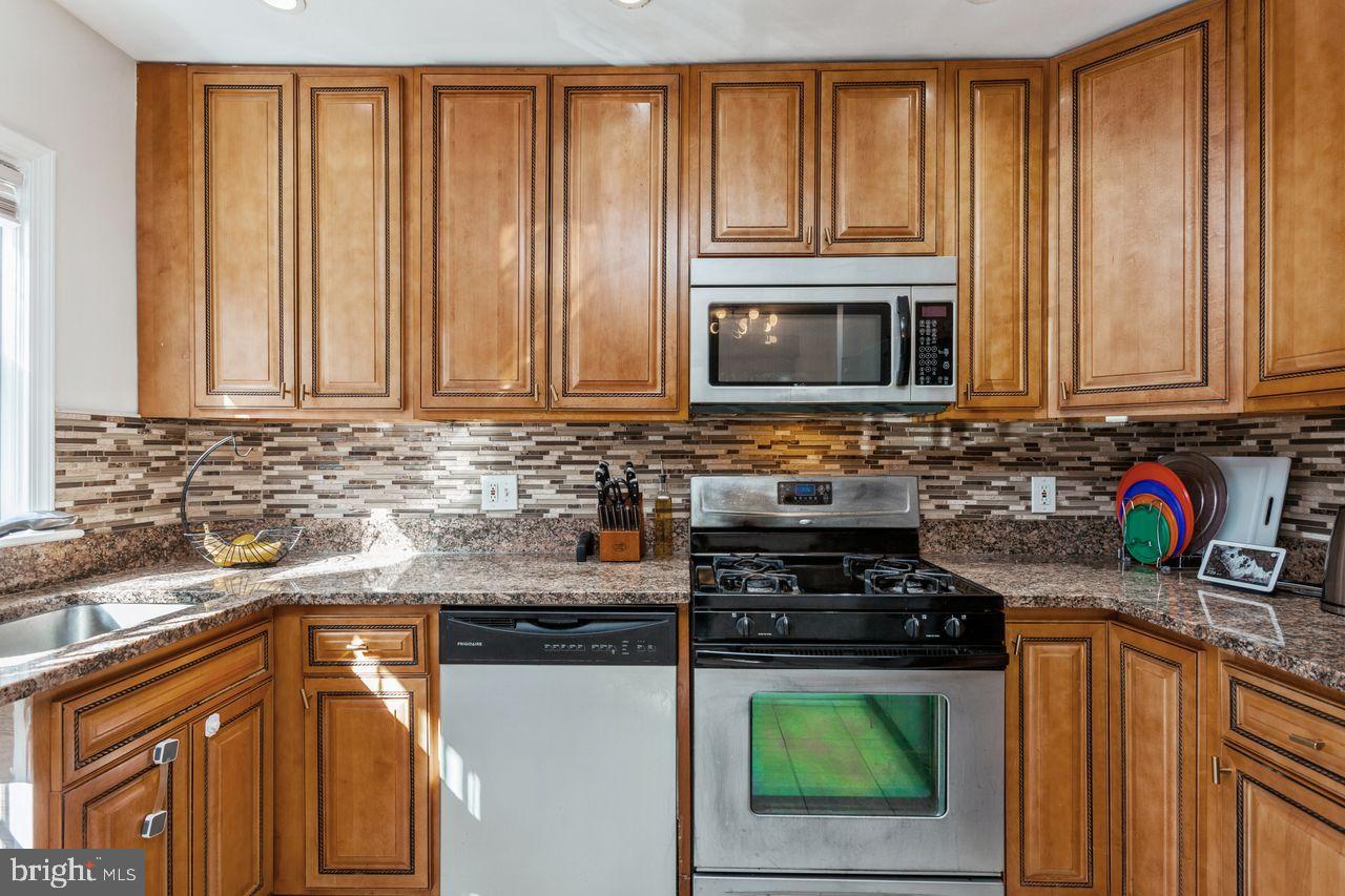 3920 Rexmere Road Baltimore, MD 21218 - Photo 10 of 35 a kitchen with granite countertop cabinets stainless steel appliances a sink and a counter space