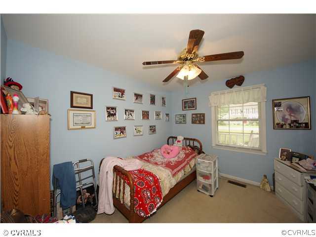 12112 Quito Road Midlothian, VA 23112 - Photo 5 of 7 a bedroom with a bed and a chandelier