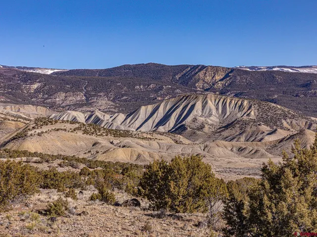 a view of a dry yard with mountains in the background