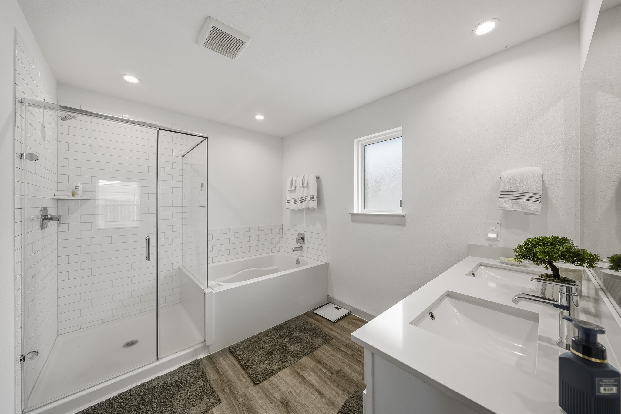 919 Tall Shire Court Rosharon, TX 77583 - Photo 11 of 19 Designed for convenience, this primary bathroom showcases a long double vanity, subway tile accents, and a standalone shower paired with a deep soaking tub.