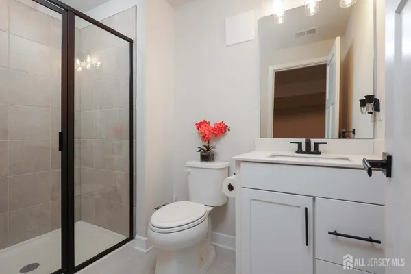 a bathroom with a sink vanity mirror and toilet