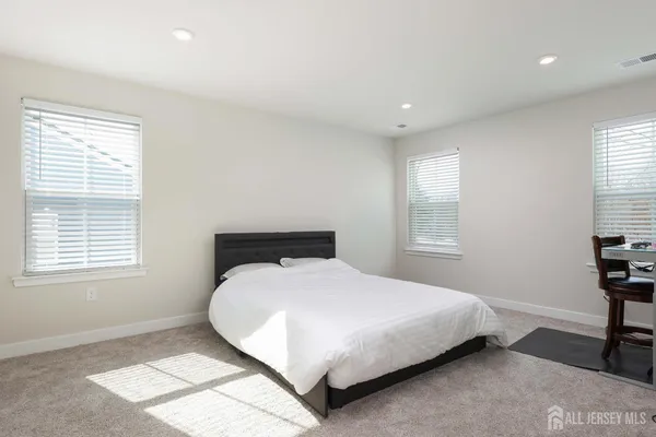 a large bedroom with a bed and a window
