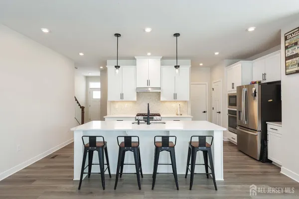 a kitchen with stainless steel appliances kitchen island a chandelier and refrigerator