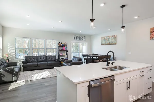 a view of a kitchen with kitchen island a sink stainless steel appliances and living room view