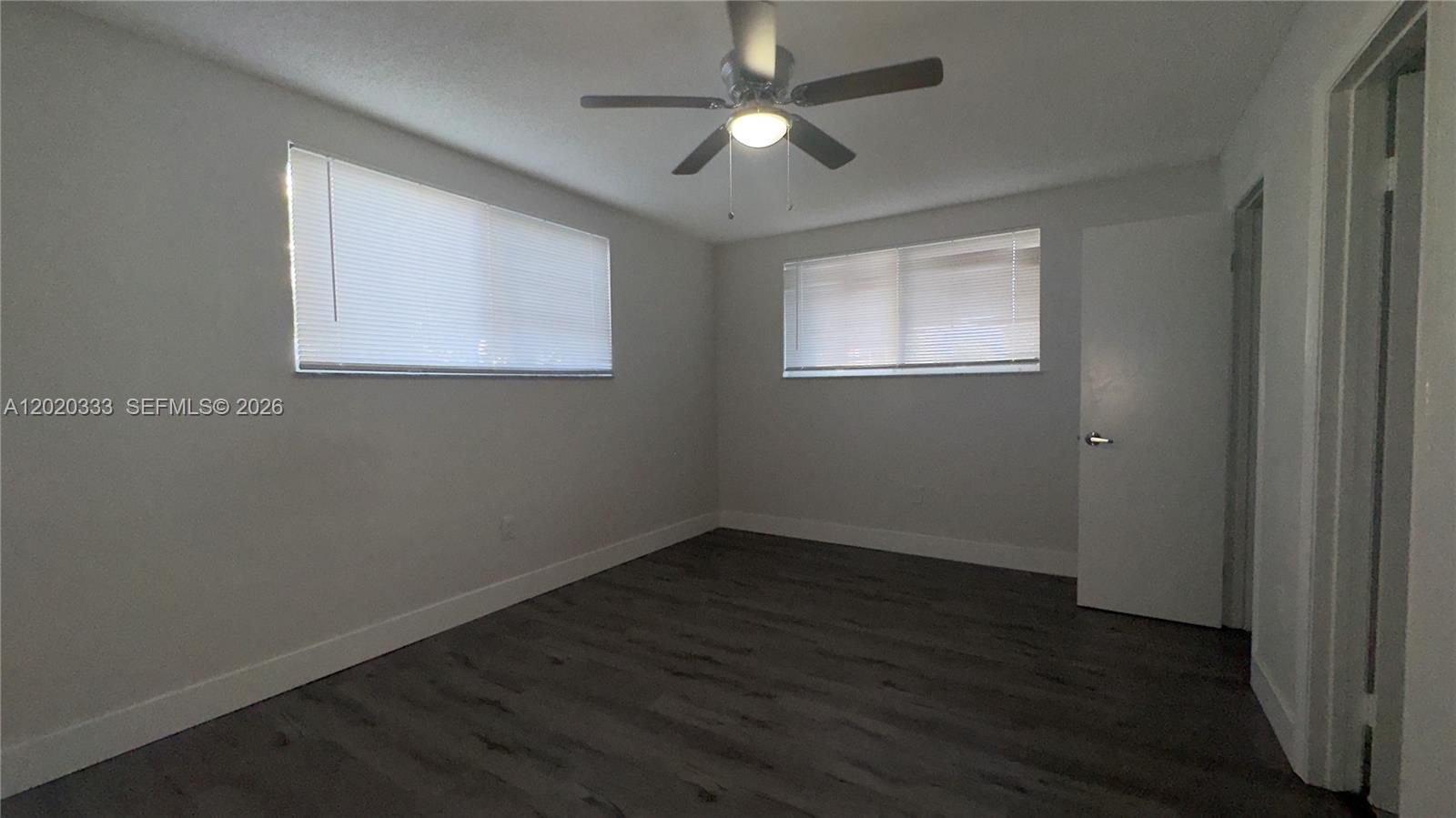 11309 Southwest 200th Street, Unit 103C Miami, FL 33157 - Photo 11 of 18 a view of an empty room with wooden floor and a window