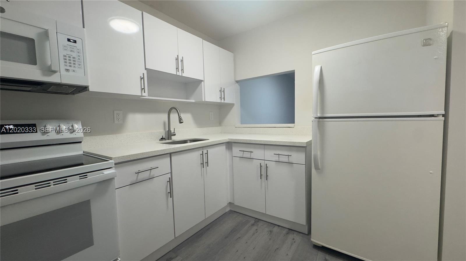 11309 Southwest 200th Street, Unit 103C Miami, FL 33157 - Photo 2 of 18 a kitchen with a refrigerator sink and cabinets