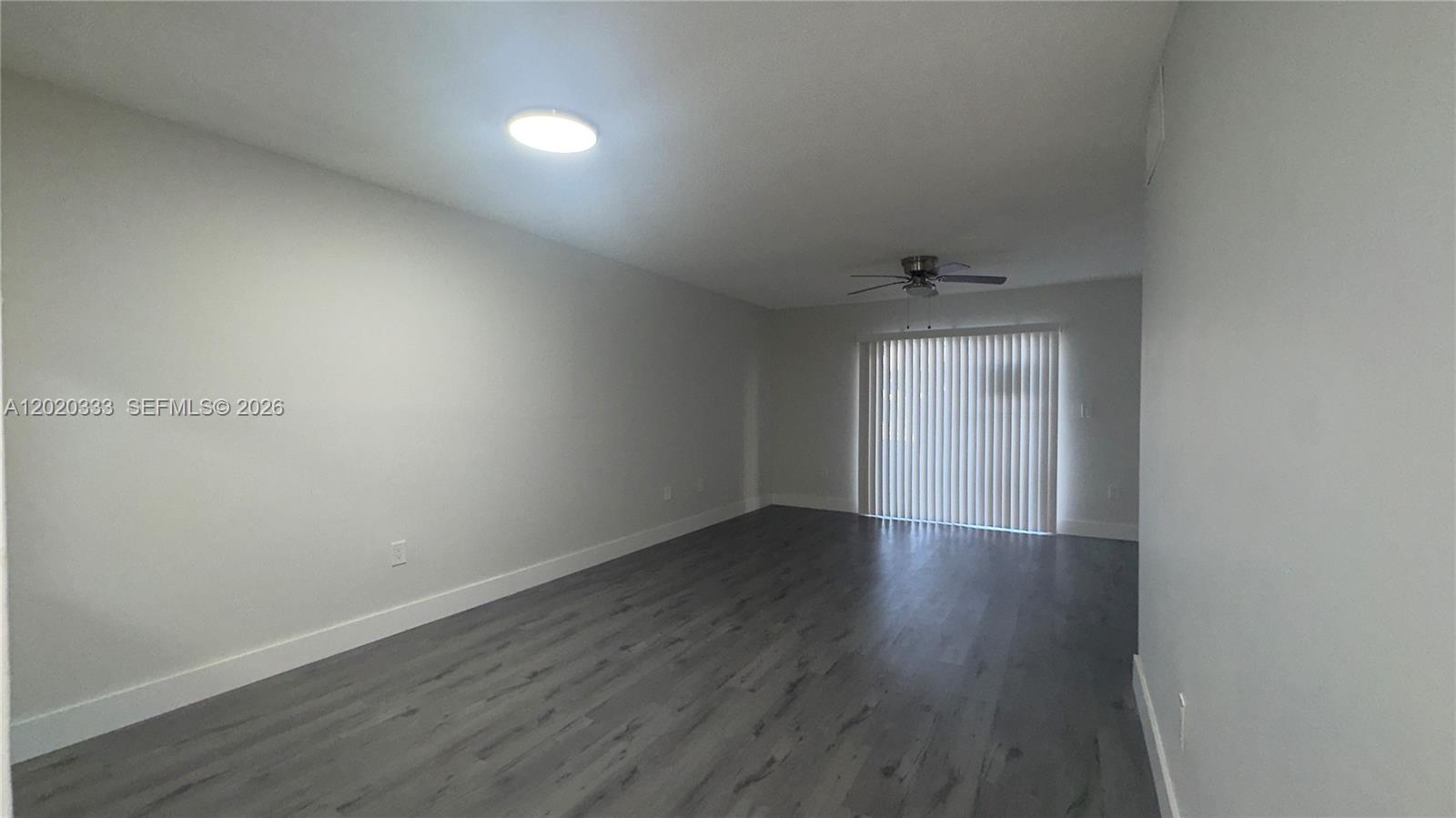 11309 Southwest 200th Street, Unit 103C Miami, FL 33157 - Photo 4 of 18 an empty room with wooden floor and windows