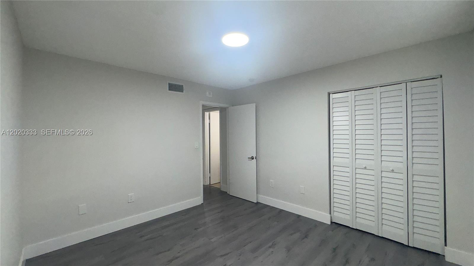 11309 Southwest 200th Street, Unit 103C Miami, FL 33157 - Photo 5 of 18 an empty room with wooden floor and windows