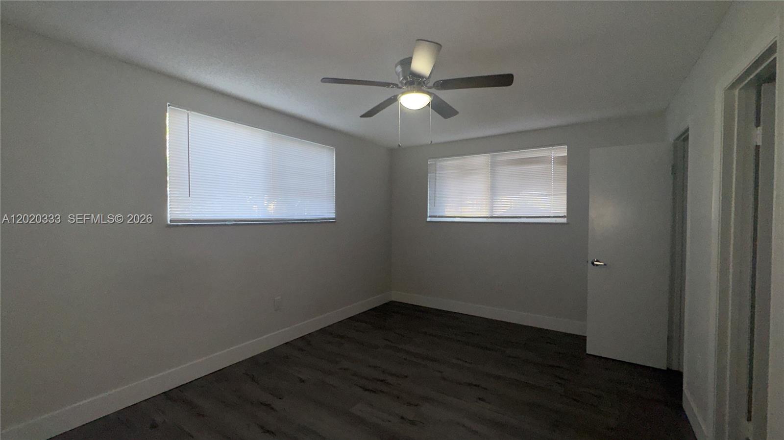 11309 Southwest 200th Street, Unit 103C Miami, FL 33157 - Photo 10 of 18 a view of an empty room with wooden floor and a window