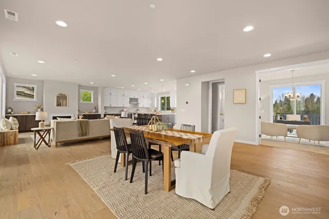 a living room with furniture a chandelier a large window and wooden floor