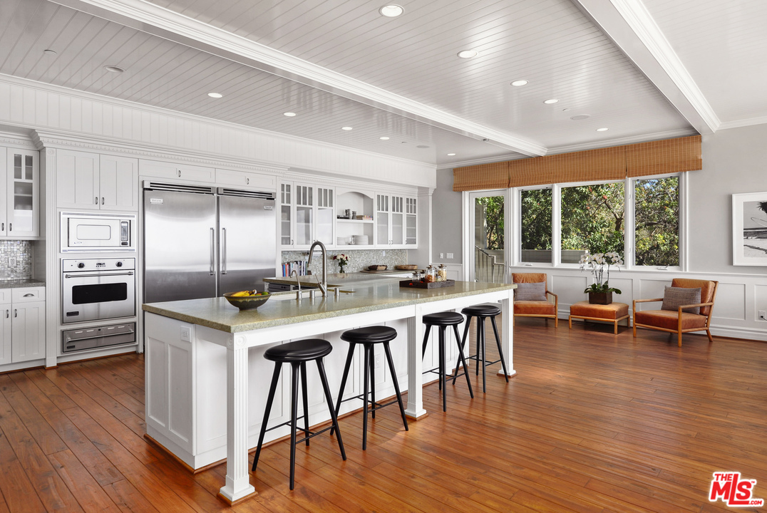 31412 Broad Beach Road Malibu, CA 90265 - Photo 14 of 43 a kitchen with stainless steel appliances granite countertop a table chairs sink and wooden floor