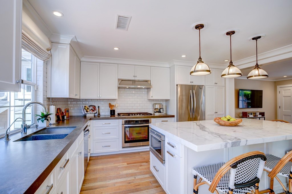 7936 Paseo Del Ocaso La Jolla, CA 92037 - Photo 14 of 43 a kitchen with stainless steel appliances granite countertop a sink stove and refrigerator