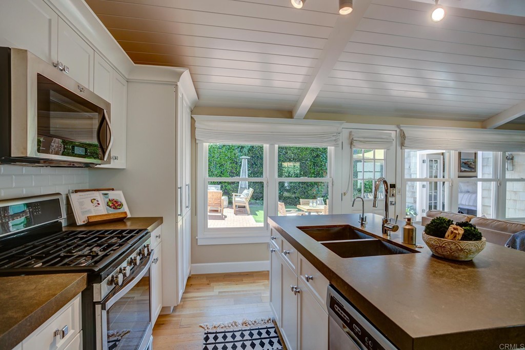 7936 Paseo Del Ocaso La Jolla, CA 92037 - Photo 28 of 43 a kitchen that has a sink a stove and a microwave