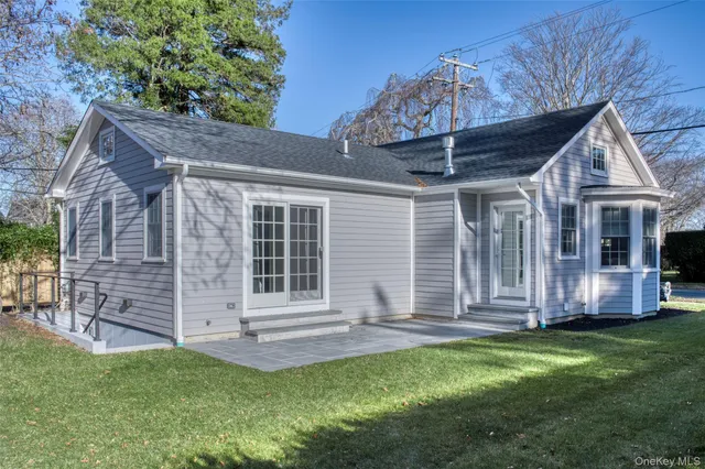 a view of a house with a yard chairs and table in a patio