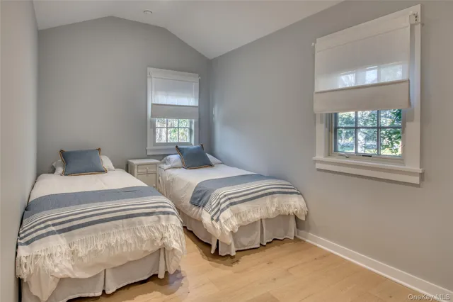 a bedroom with two beds and a window