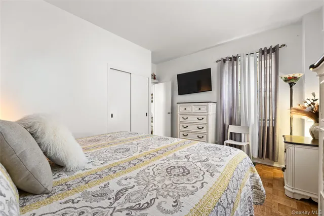 a bedroom with a large bed and a flat screen tv