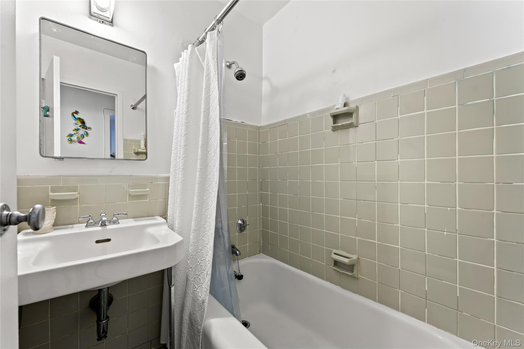 3 Fordham Hill Ovl, Unit 3C Bronx, NY 10468 - Photo 12 of 24 a bathroom with a sink mirror and shower