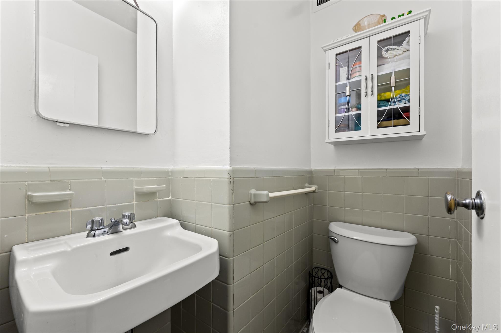 3 Fordham Hill Ovl, Unit 3C Bronx, NY 10468 - Photo 13 of 24 a bathroom with a sink mirror and toilet
