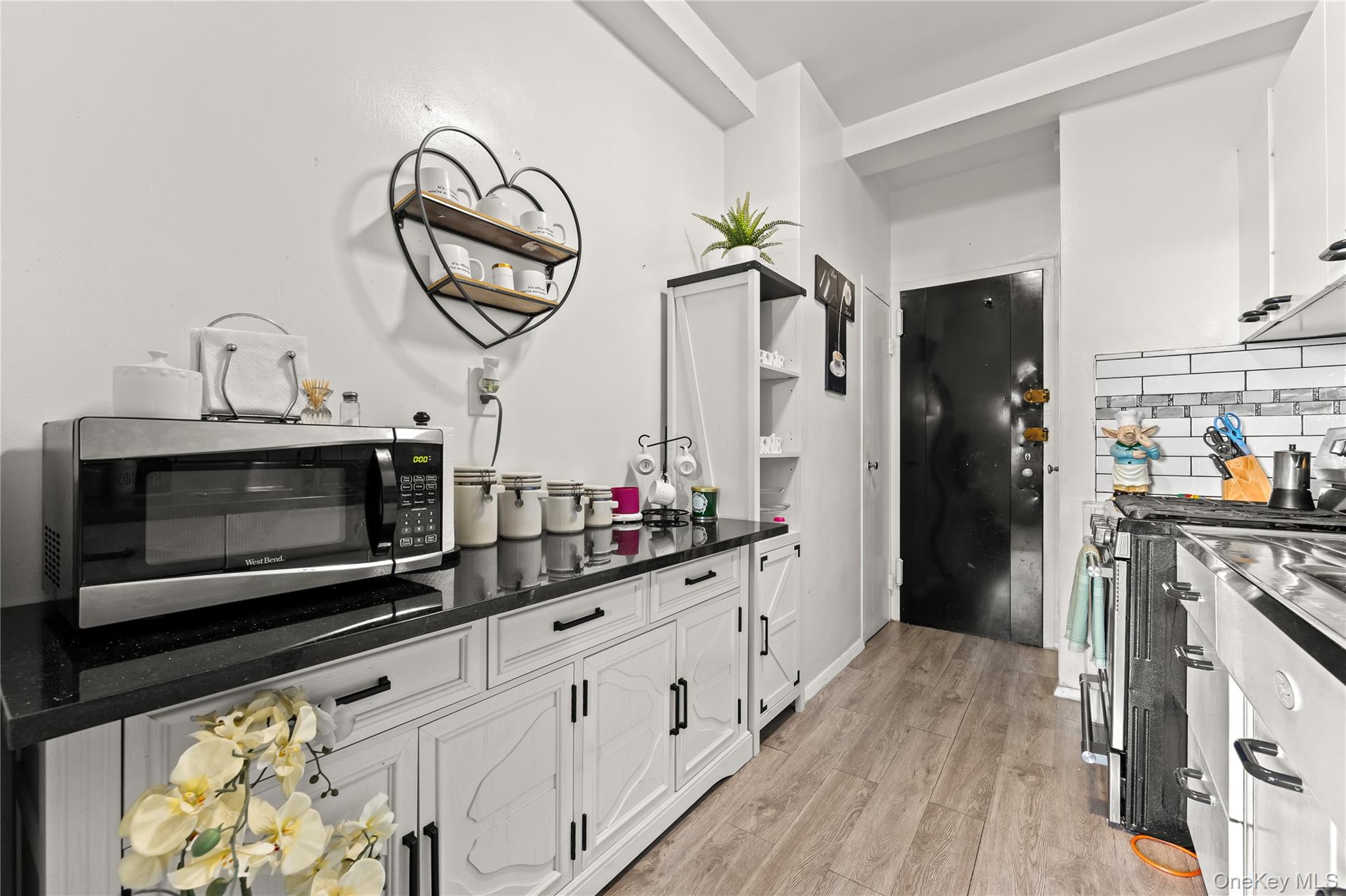 3 Fordham Hill Ovl, Unit 3C Bronx, NY 10468 - Photo 8 of 24 a kitchen with stainless steel appliances a stove microwave and a refrigerator