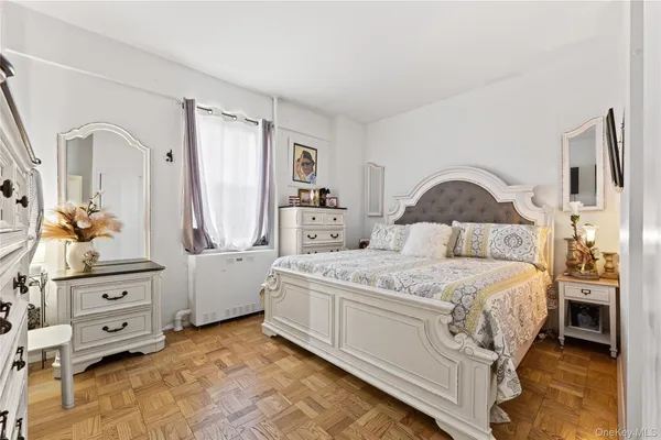 a bedroom with a large bed and wooden floor