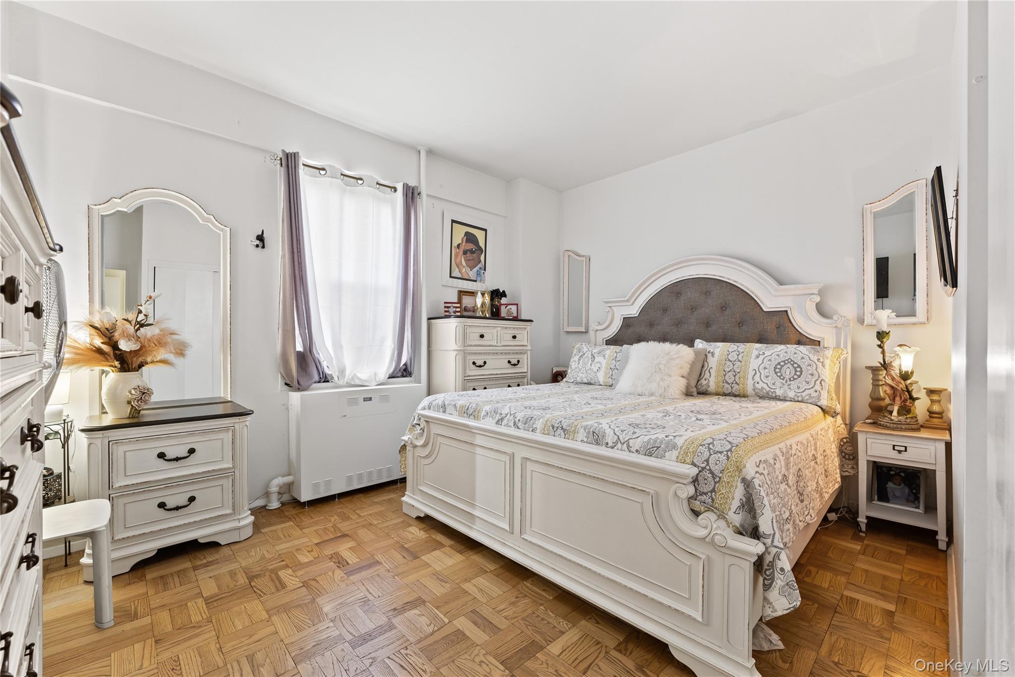3 Fordham Hill Ovl, Unit 3C Bronx, NY 10468 - Photo 10 of 24 a bedroom with a large bed and wooden floor