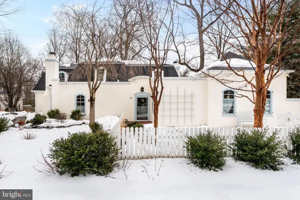 a white house that has a tree in front of it