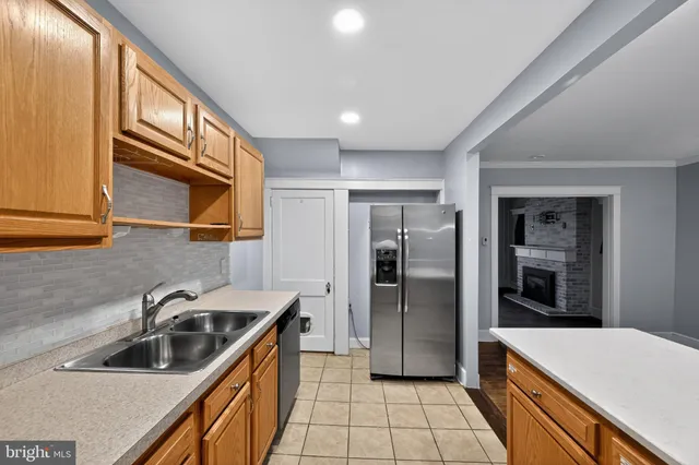 a kitchen that has a sink stainless steel appliances a refrigerator and a sink