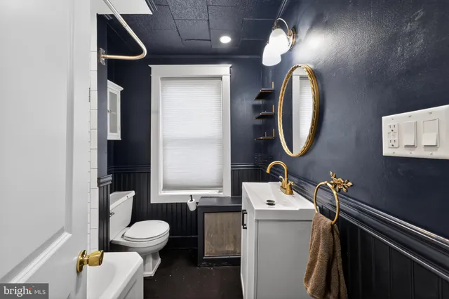 a bathroom with a toilet sink and mirror