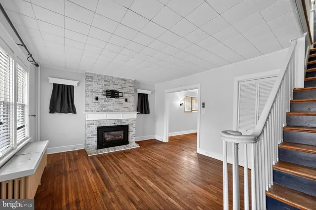 a view of a livingroom with wooden floor and a fireplace