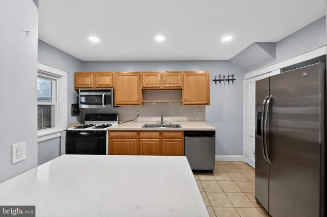 a kitchen with stainless steel appliances granite countertop refrigerator sink and stove