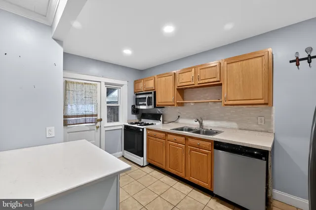 a kitchen with stainless steel appliances granite countertop a sink stove cabinets and wooden floor