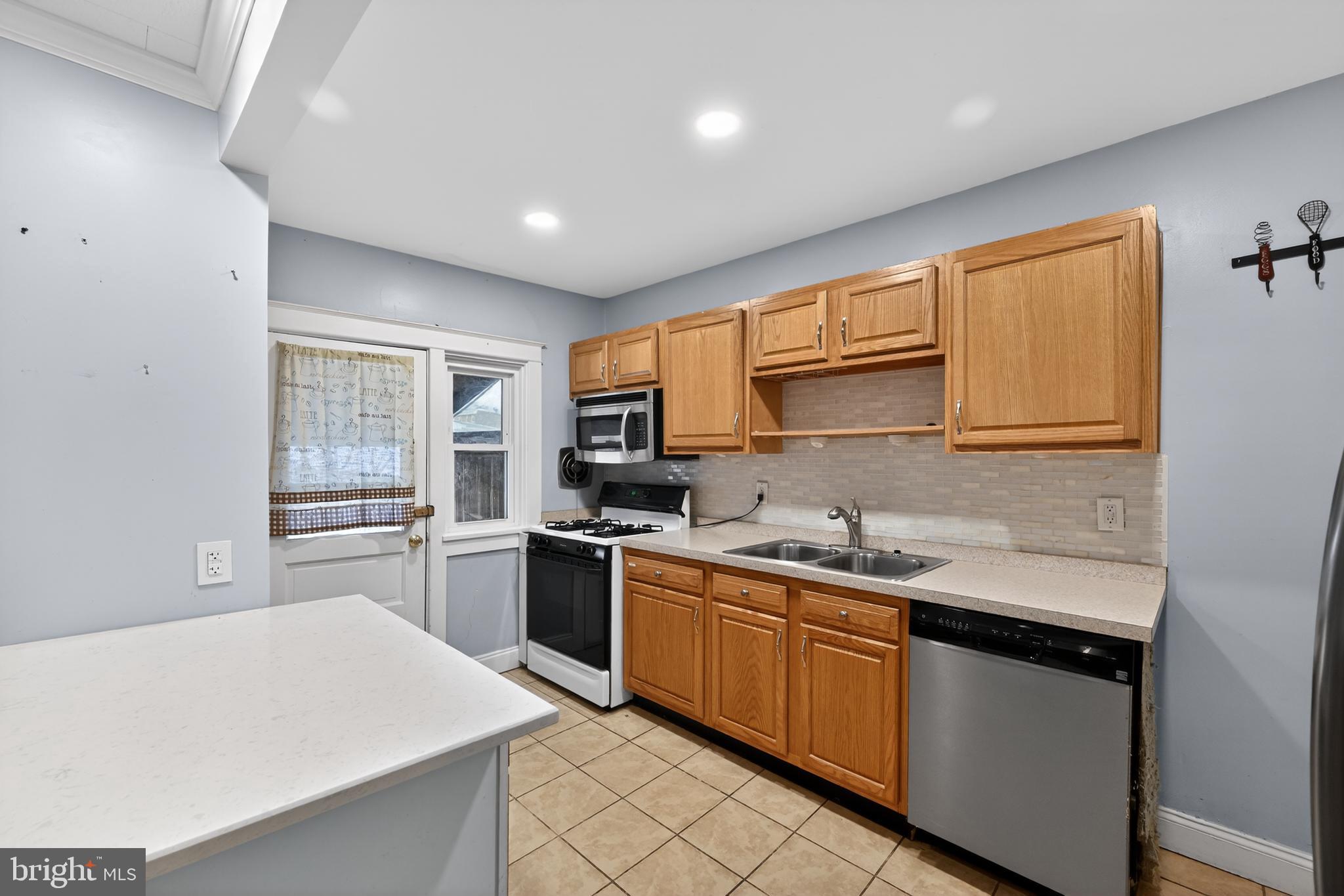 108 South Pearl Street Lancaster, PA 17603 - Photo 10 of 30 a kitchen with stainless steel appliances granite countertop a sink stove cabinets and wooden floor