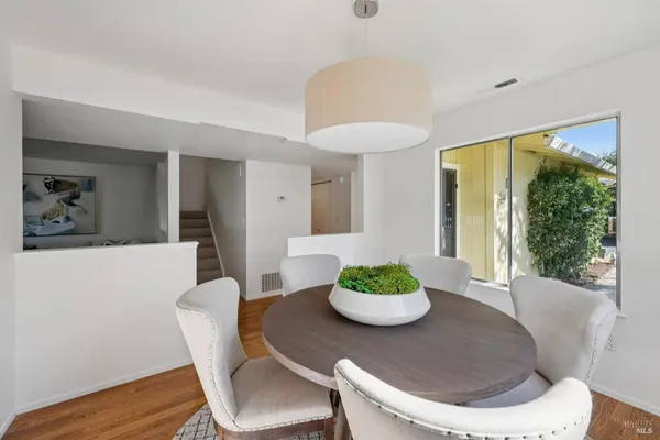 a dining room with furniture a window and a potted plant