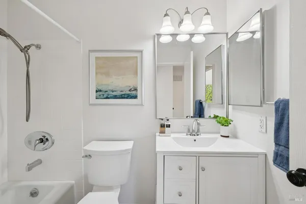 a view of bathroom with a sink and mirror with toilet