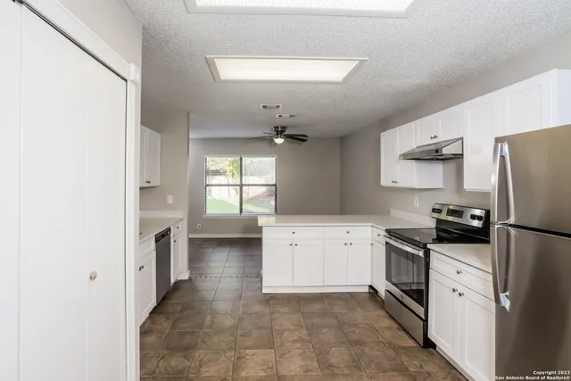 a kitchen with a refrigerator sink stove and cabinets