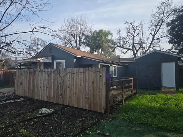 a view of a house with a wooden fence and a bench