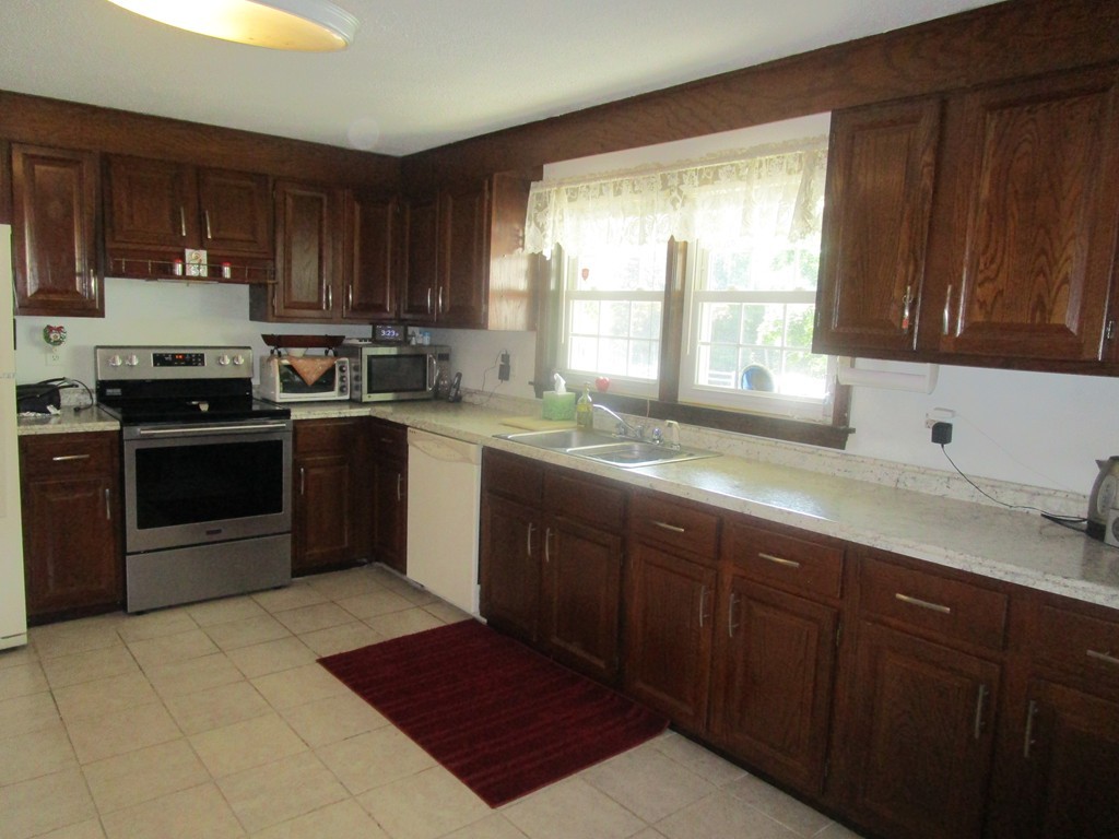 23 Oak Street, Unit E Methuen, MA 01844 - Photo 12 of 26 a kitchen with a sink stove top oven and cabinets